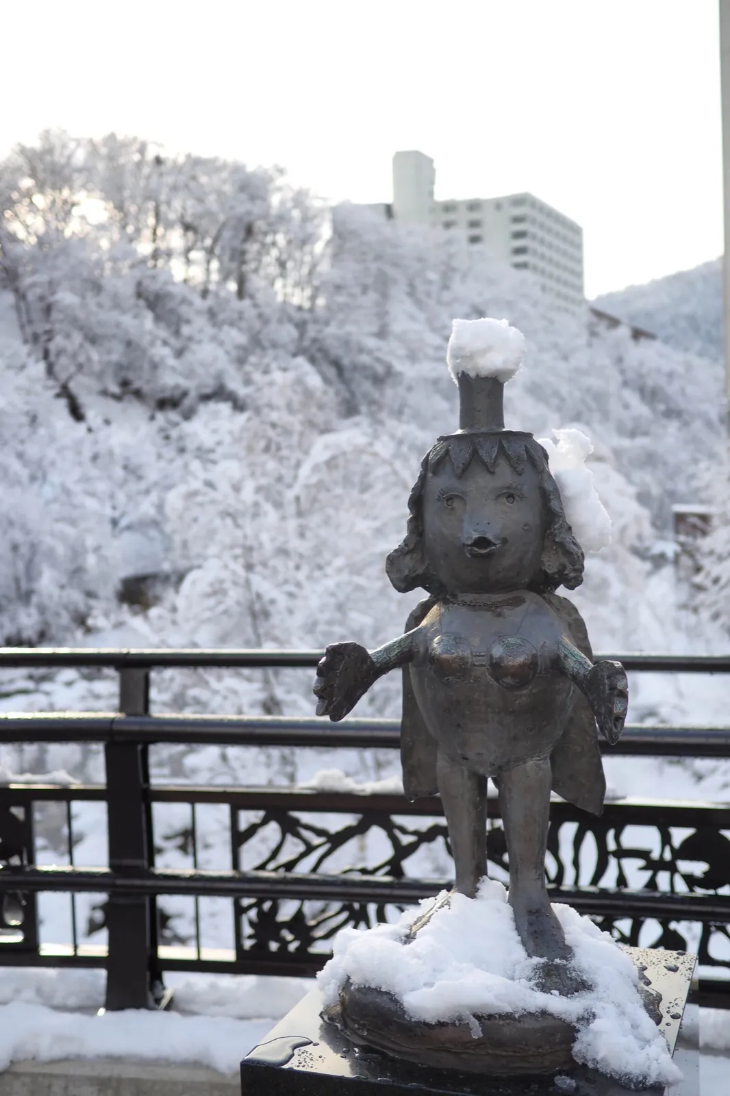 橋上河童像與雪中溫泉街